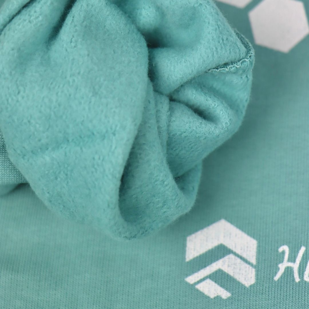 organic sweatshirt in teal, sleeve folded back to show cosiness inside the sleeve